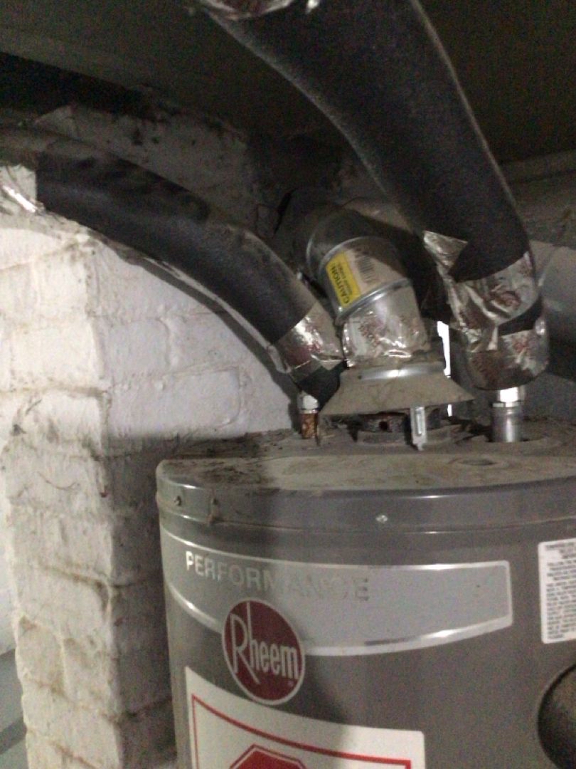 Old Rheem water heater with foil tape and corroded flue before replacement - Northeast Ohio